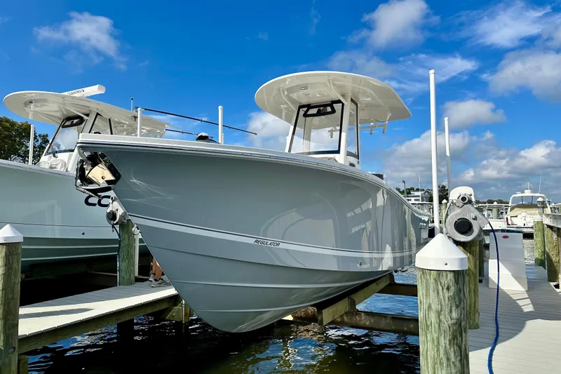 Slide: The Image of 2025 Regulator 23 boat docked at marina under clear blue sky. - 3