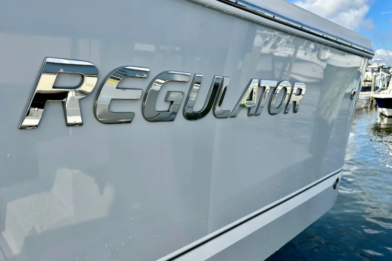 Slide: The Image of 2025 Regulator 23 boat with chrome logo, docked by the water. - 4