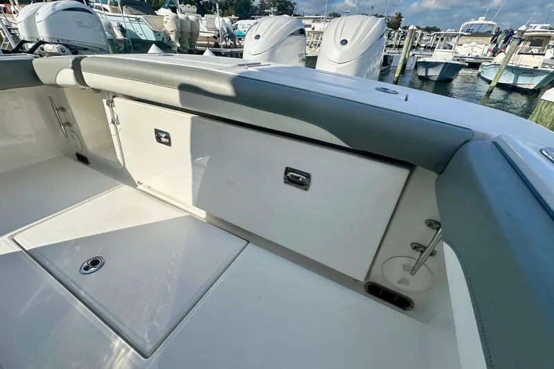 Slide: The Image of 2025 Regulator 23 boat interior with storage compartments and seating, docked at a marina. - 7