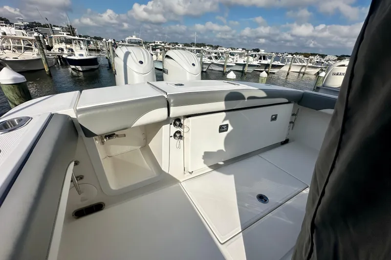 Slide: The Image of 2025 Regulator 23 boat interior with seating, docked at marina under cloudy sky. - 8