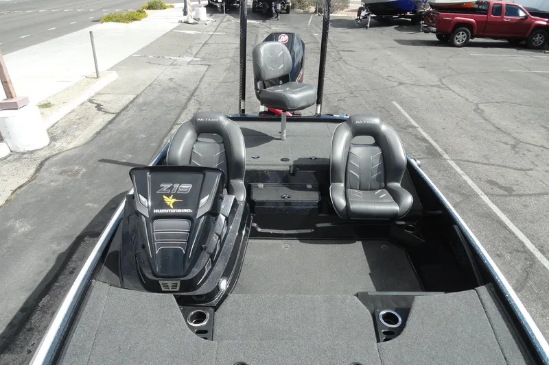 Slide: The Image of 2021 Nitro Z19 Pro boat interior with seating and control panel, parked on pavement. - 16