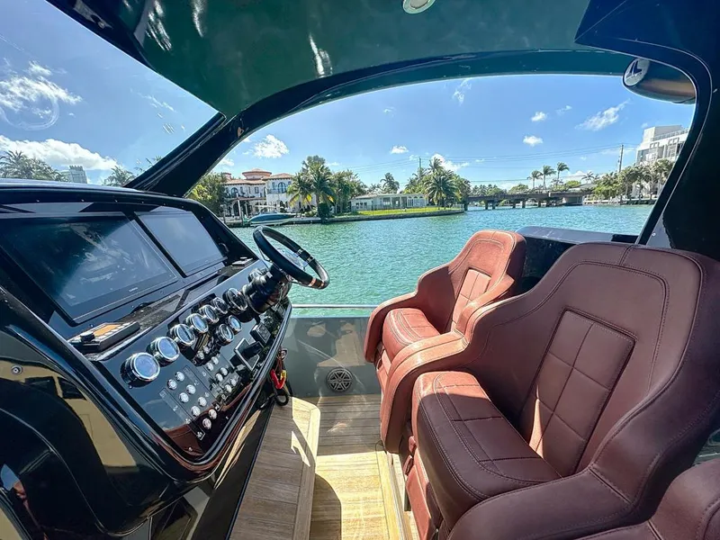 Slide: The Image of Interior of 2019 SACS Rebel 40 boat with luxurious seating and control panel, overlooking waterway. - 14