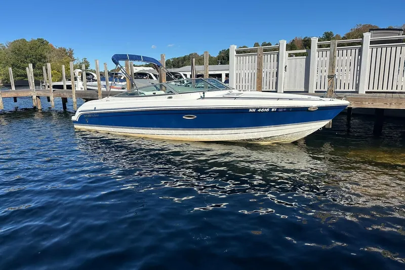Slide: The Image of 2003 Formula 260 Sun Sport boat docked on a sunny day, blue and white design. - 3