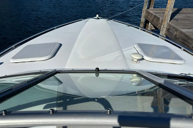 Slide: The Image of 2003 Formula 260 Sun Sport boat docked, view from the bow with clear water backdrop. - 8