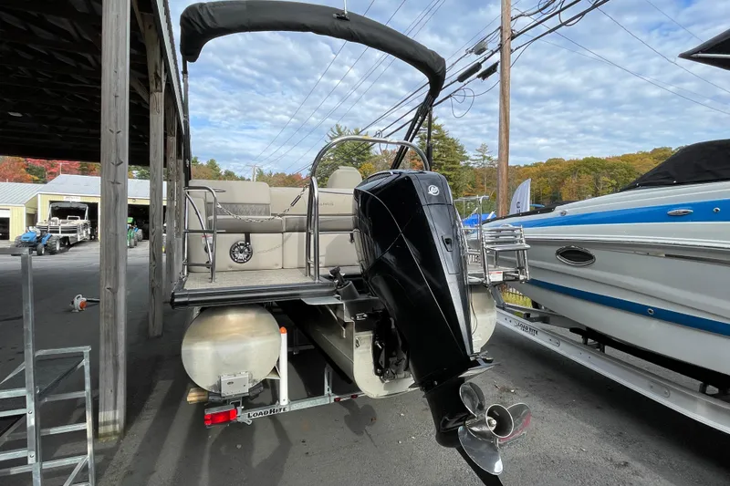 Slide: The Image of 2021 Harris Sunliner 230 pontoon boat with outboard motor, parked on a trailer. - 20