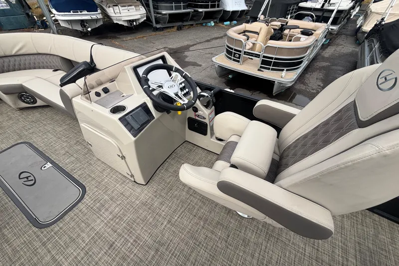 Slide: The Image of 2021 Harris Sunliner 230 boat interior with steering console and plush seating. - 8