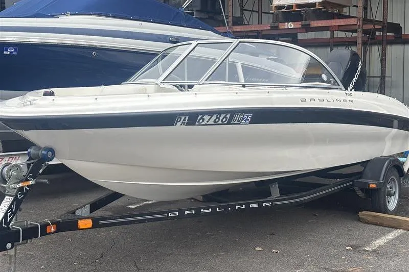 The Image of 2011 Bayliner 160 Bowrider boat on trailer in storage facility. - 0