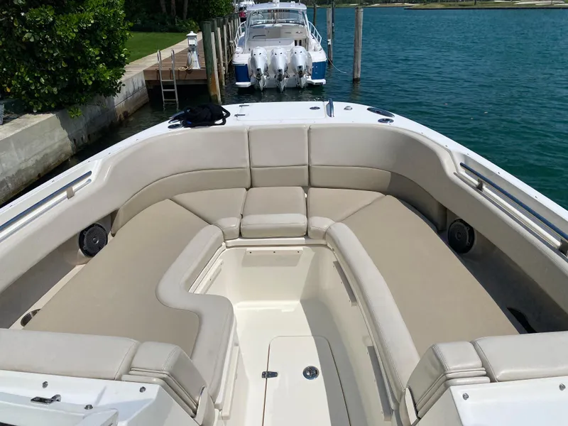 Slide: The Image of 2017 Boston Whaler 320 Vantage boat with spacious seating, docked by the water. - 16