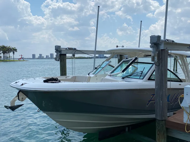 Slide: The Image of 2017 Boston Whaler 320 Vantage boat docked on a sunny day with city skyline. - 2