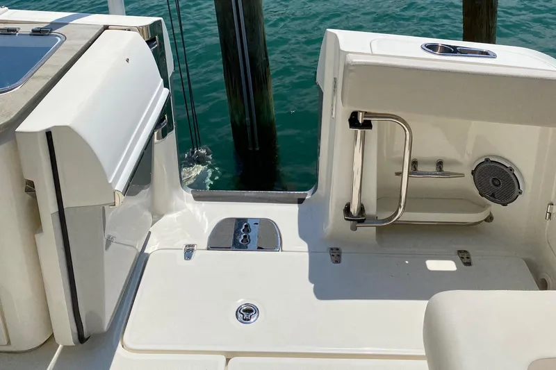 Slide: The Image of 2017 Boston Whaler 320 Vantage boat deck with seating and railing, docked by water. - 21