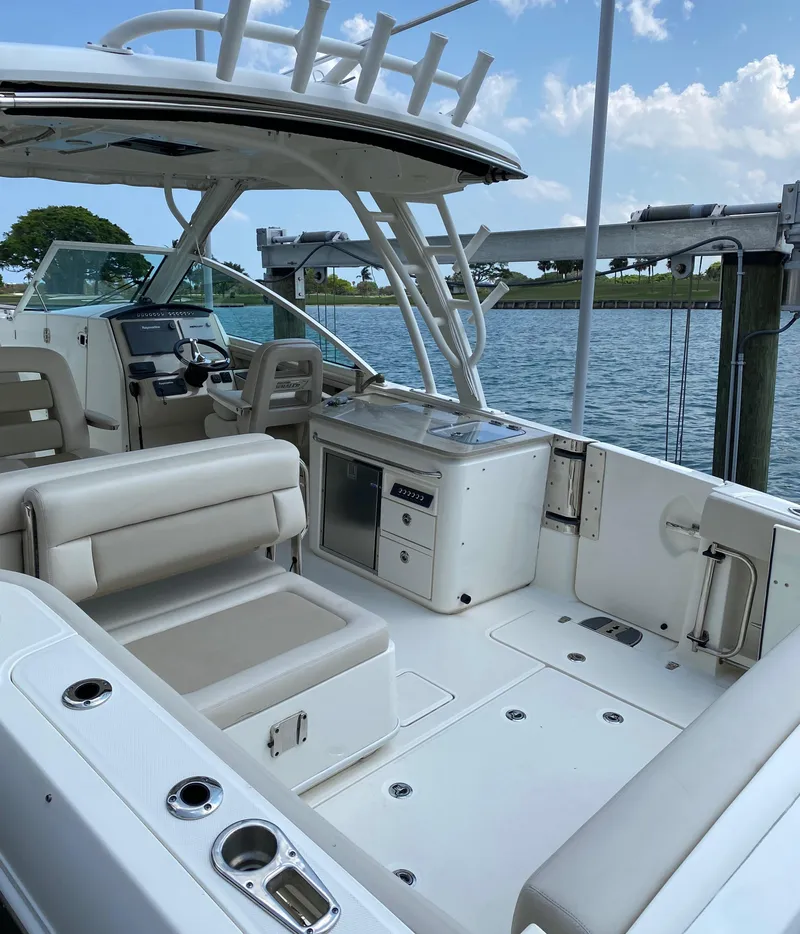 Slide: The Image of 2017 Boston Whaler 320 Vantage boat interior with seating and helm, docked by the water. - 22