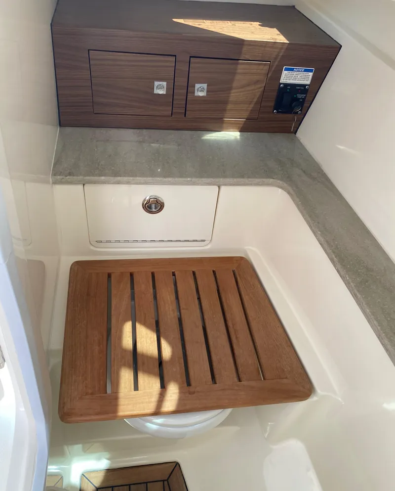 Slide: The Image of 2017 Boston Whaler 320 Vantage interior with wooden accents and storage compartments. - 25