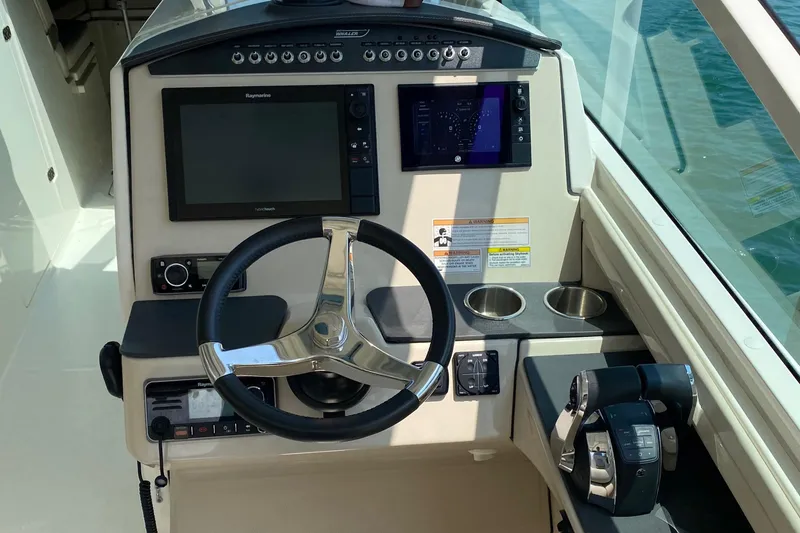 Slide: The Image of 2017 Boston Whaler 320 Vantage helm with steering wheel, controls, and navigation screens. - 27