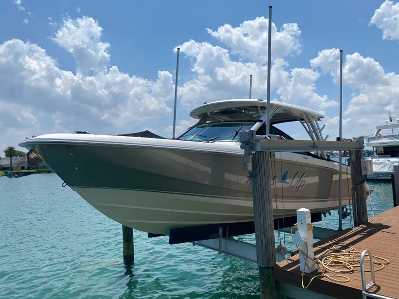 Slide: The Image of 2017 Boston Whaler 320 Vantage boat docked on a lift under a sunny sky. - 5