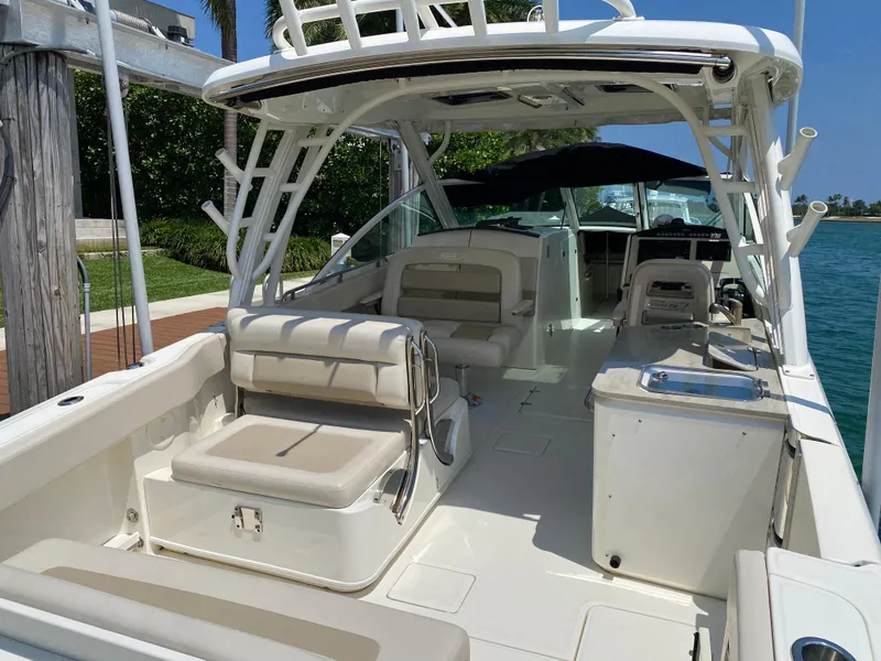 Slide: The Image of 2017 Boston Whaler 320 Vantage boat interior with seating and helm, docked by the water. - 8