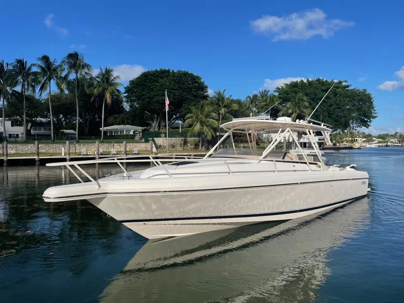The Image of 2007 Intrepid 35 Walkaround boat on calm water, surrounded by palm trees and clear blue sky. - 0