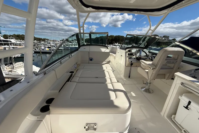 Slide: The Image of 2015 Boston Whaler 270 Vantage boat interior with seating and helm, docked at marina. - 10