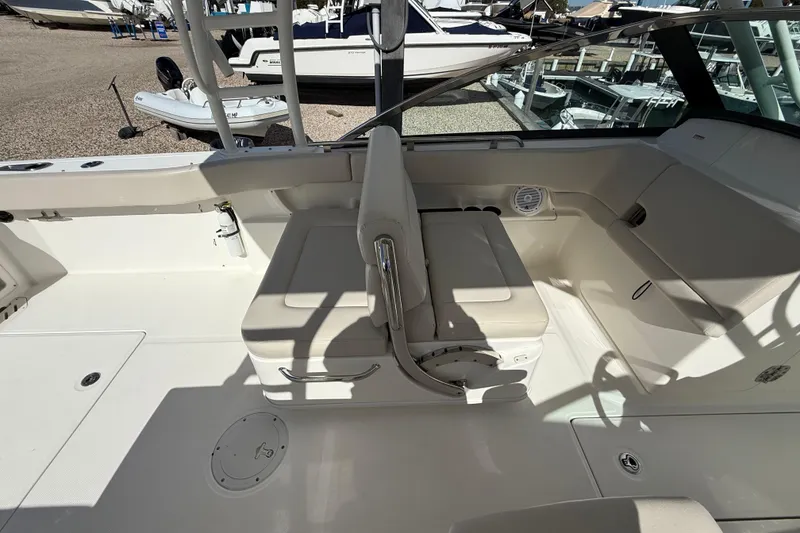 Slide: The Image of 2015 Boston Whaler 270 Vantage interior with white seating and storage compartments. - 11