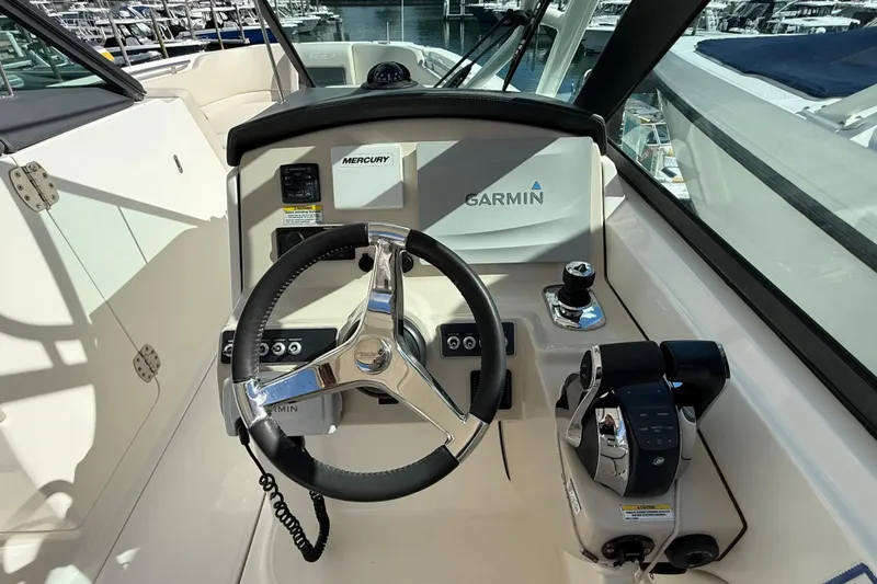 Slide: The Image of Boston Whaler 270 Vantage 2015 helm with Garmin and Mercury controls, docked at marina. - 14