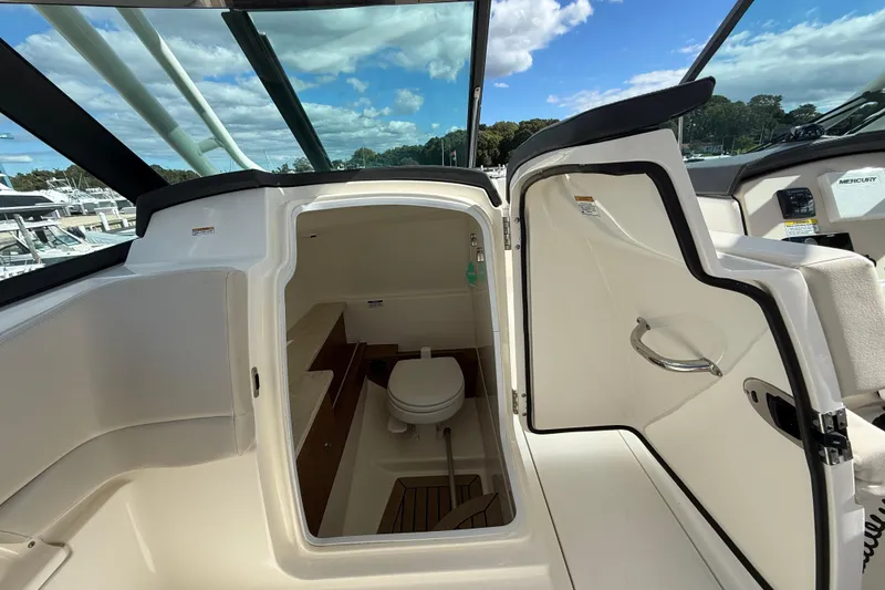 Slide: The Image of 2015 Boston Whaler 270 Vantage boat interior with open cabin door and toilet. - 16
