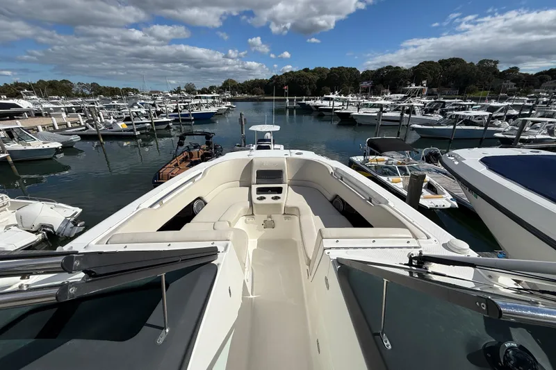 Slide: The Image of 2015 Boston Whaler 270 Vantage boat docked in a marina under a partly cloudy sky. - 18