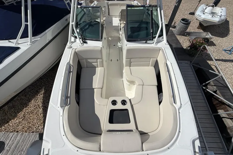 Slide: The Image of 2015 Boston Whaler 270 Vantage boat interior with seating and console, docked at marina. - 19