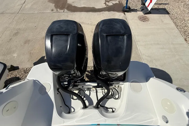 Slide: The Image of Twin outboard motors on a 2015 Boston Whaler 270 Vantage boat, docked on concrete. - 2