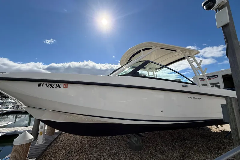 Slide: The Image of 2015 Boston Whaler 270 Vantage boat docked under a sunny sky. - 22