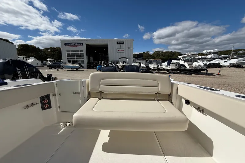 Slide: The Image of 2015 Boston Whaler 270 Vantage boat interior with seating, docked at a marina under blue skies. - 5
