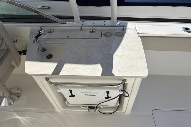 Slide: The Image of 2015 Boston Whaler 270 Vantage boat sink and countertop area with storage below. - 8