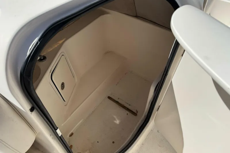 Slide: The Image of 2007 Hurricane SunDeck 217 OB storage compartment interior, featuring a small access panel. - 15