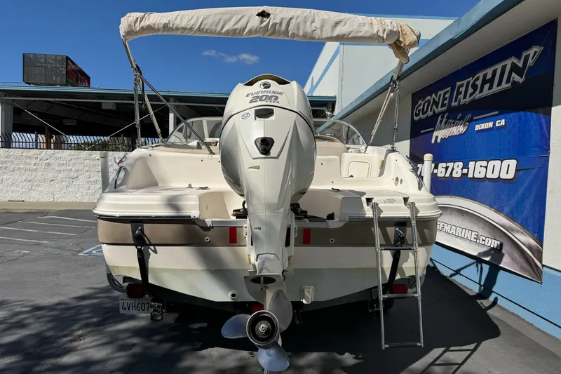 Slide: The Image of 2007 Hurricane SunDeck 217 OB boat with Evinrude 200 engine, parked at dealership. - 4