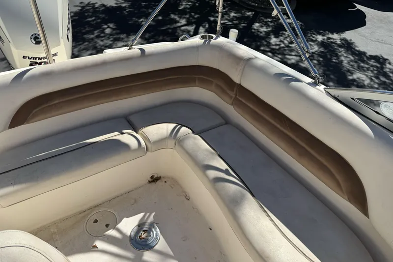 Slide: The Image of 2007 Hurricane SunDeck 217 OB boat interior with cushioned seating and Evinrude motor. - 8