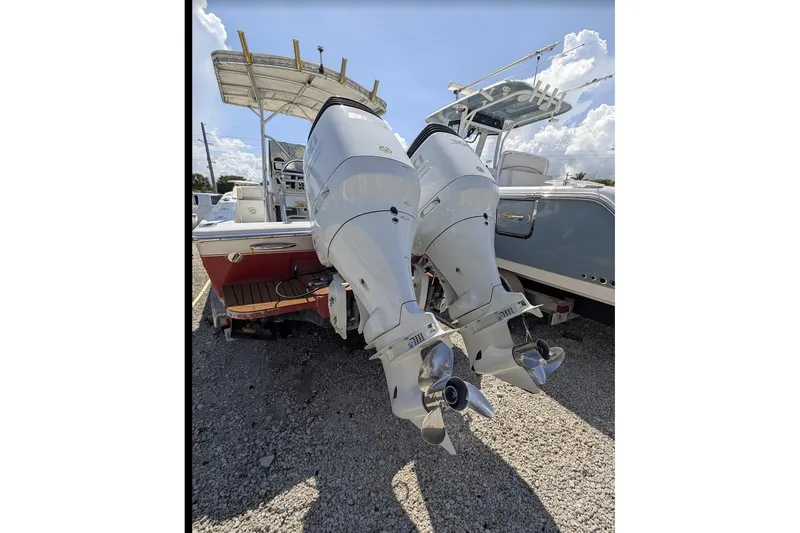 Slide: The Image of 1989 Intrepid 29 boat with dual outboard motors on gravel lot. - 4