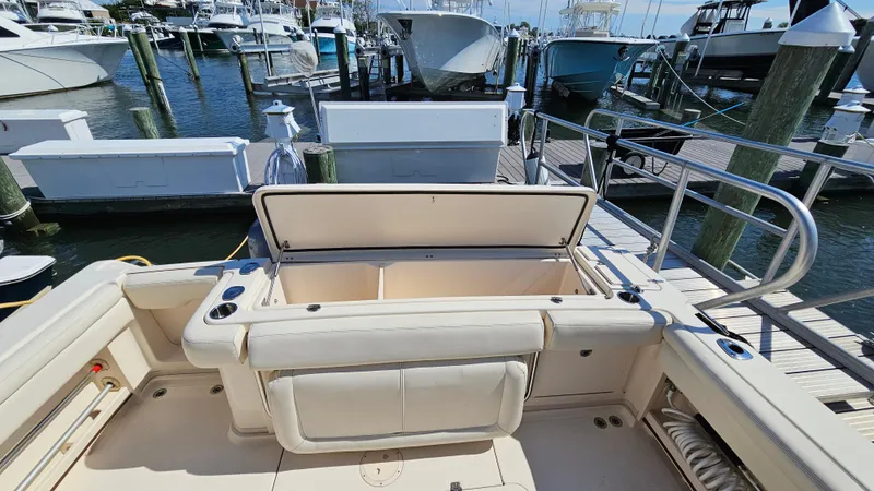 Slide: The Image of 2016 Grady-White Express 330 boat interior at dock, open storage compartment, marina background. - 16