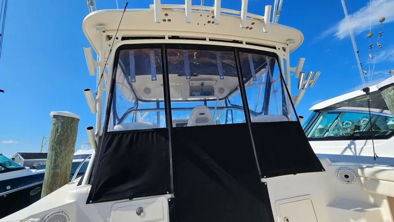 Slide: The Image of 2016 Grady-White Express 330 boat with covered cockpit, docked under clear blue sky. - 21