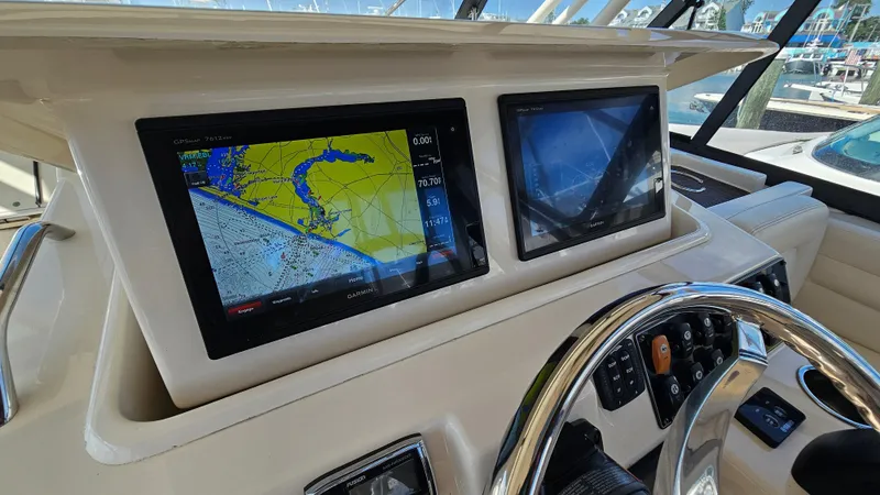 Slide: The Image of 2016 Grady-White Express 330 helm with navigation screens and steering wheel. - 29