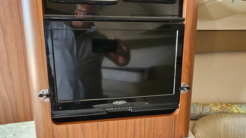 Slide: The Image of 2016 Grady-White Express 330 interior with mounted TV and wood paneling. - 39