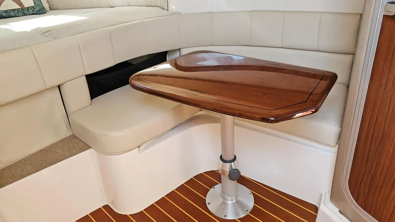 Slide: The Image of 2016 Grady-White Express 330 interior with wooden table and cushioned seating. - 46