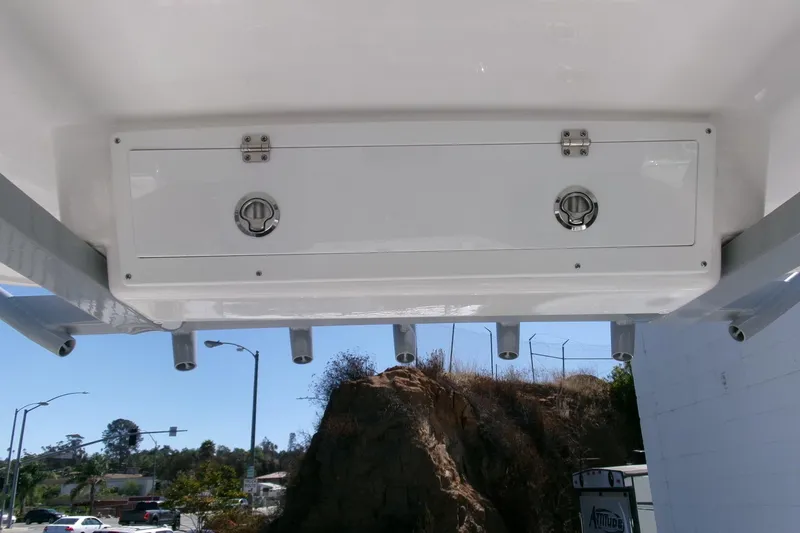 Slide: The Image of 2026 Sea Fox 268 Commander boat storage compartment with rod holders, outdoor setting. - 20