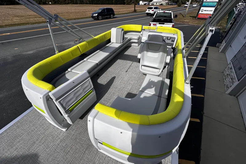 Slide: The Image of 2025 Avalon 2185 Aura Quad Lounge Twin Toon boat with vibrant yellow seating, parked roadside. - 10