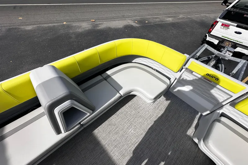 Slide: The Image of 2025 Avalon 2185 Aura Quad Lounge boat interior with yellow and gray seating, parked on a trailer. - 14