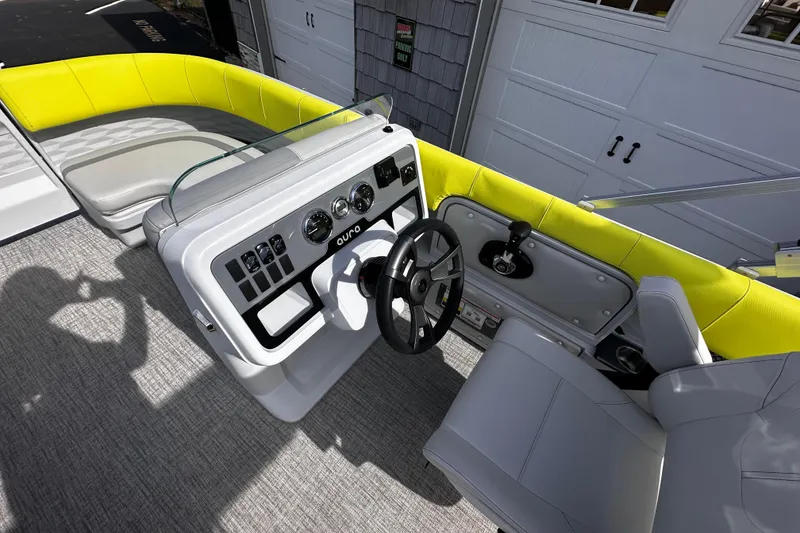 Slide: The Image of 2025 Avalon 2185 Aura Quad Lounge boat interior with modern steering console and vibrant seating. - 17