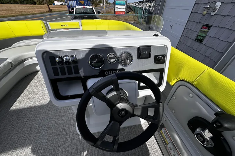 Slide: The Image of Steering console of 2025 Avalon 2185 Aura Quad Lounge boat with bright yellow seating. - 20