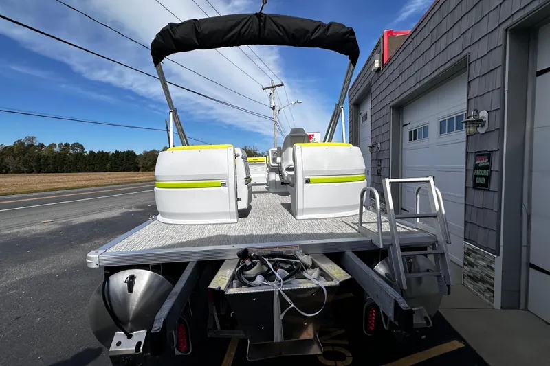 Slide: The Image of 2025 Avalon 2185 Aura Quad Lounge Twin Toon pontoon boat parked outside a building. - 6