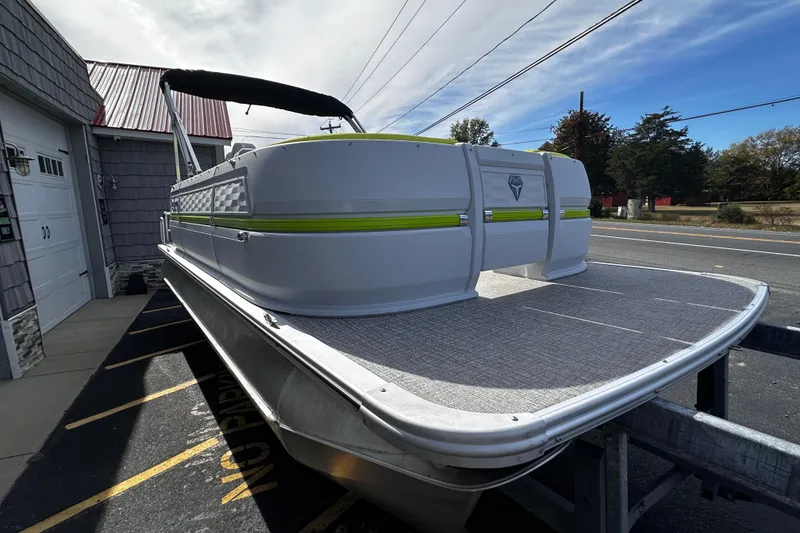 Slide: The Image of 2025 Avalon 2185 Aura Quad Lounge Twin Toon pontoon boat on trailer, side view. - 8