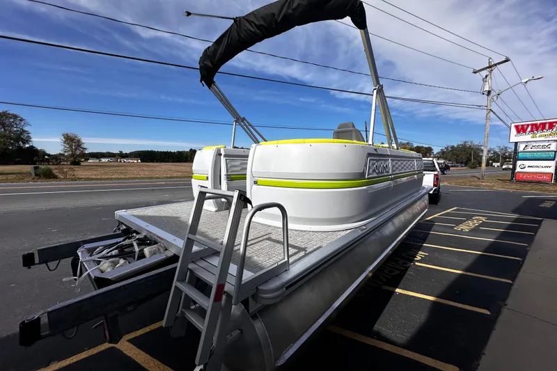 Slide: The Image of 2025 Avalon 2185 Aura Quad Lounge Twin Toon pontoon boat on trailer, parked roadside. - 9