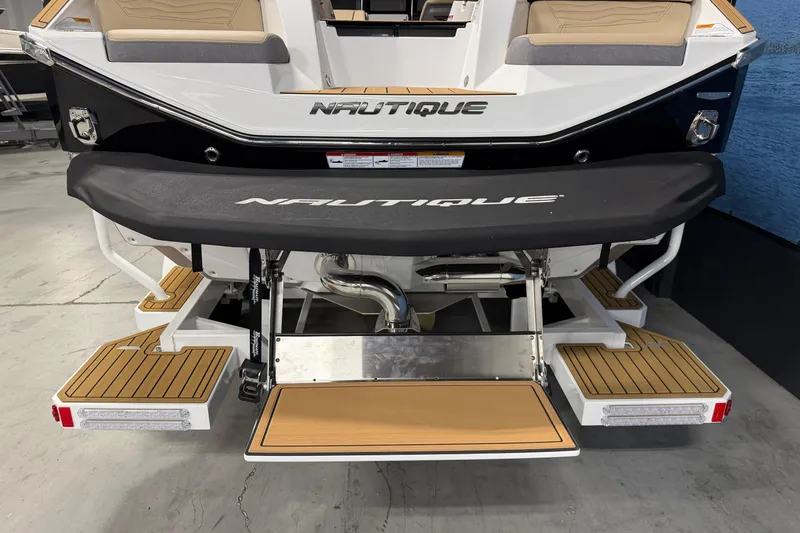 Slide: The Image of 2025 Nautique Super Air Nautique G23 boat rear view with teak platform and branding. - 4
