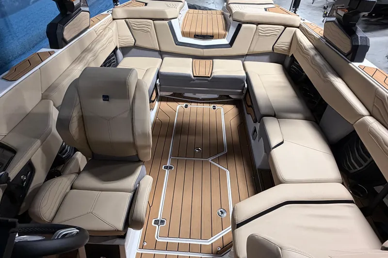 Slide: The Image of Interior of 2025 Nautique Super Air Nautique G23 with luxurious beige seating and wood flooring. - 9