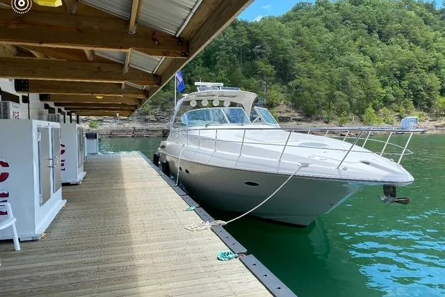 The Image of 2003 Cruisers Yachts 4370 Express docked by a scenic lakeside marina. - 0